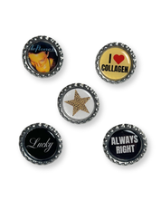 Set of five bottle cap pins with various designs on a white background