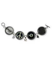 Bracelet with various charms including a peace symbol, number 8, and Coca-Cola logo on a white background.