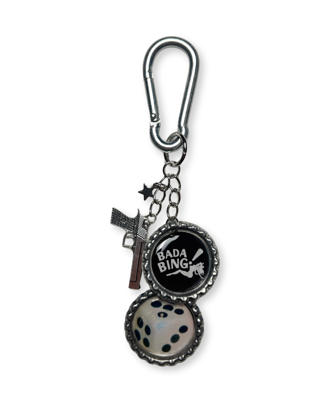 Keychain with 'Bada Bing' bottle cap charm and gun charm on a white background