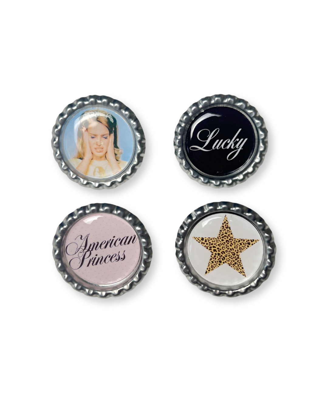 Four bottle cap pins with different designs on a white background