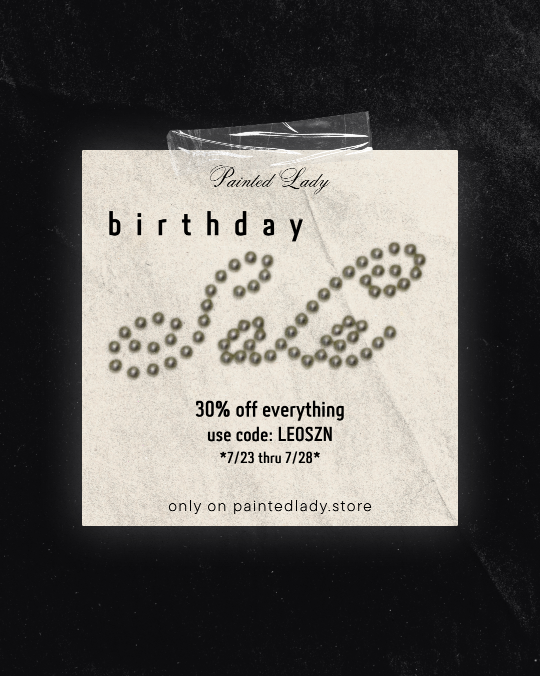 A square package insert for a 'Painted Lady' birthday decoration set, featuring the word 'bday' spelled out by small metallic beads on a textured cream card, set against a dark textured background.