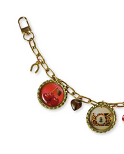 Gold bag chain with various charms on a white background