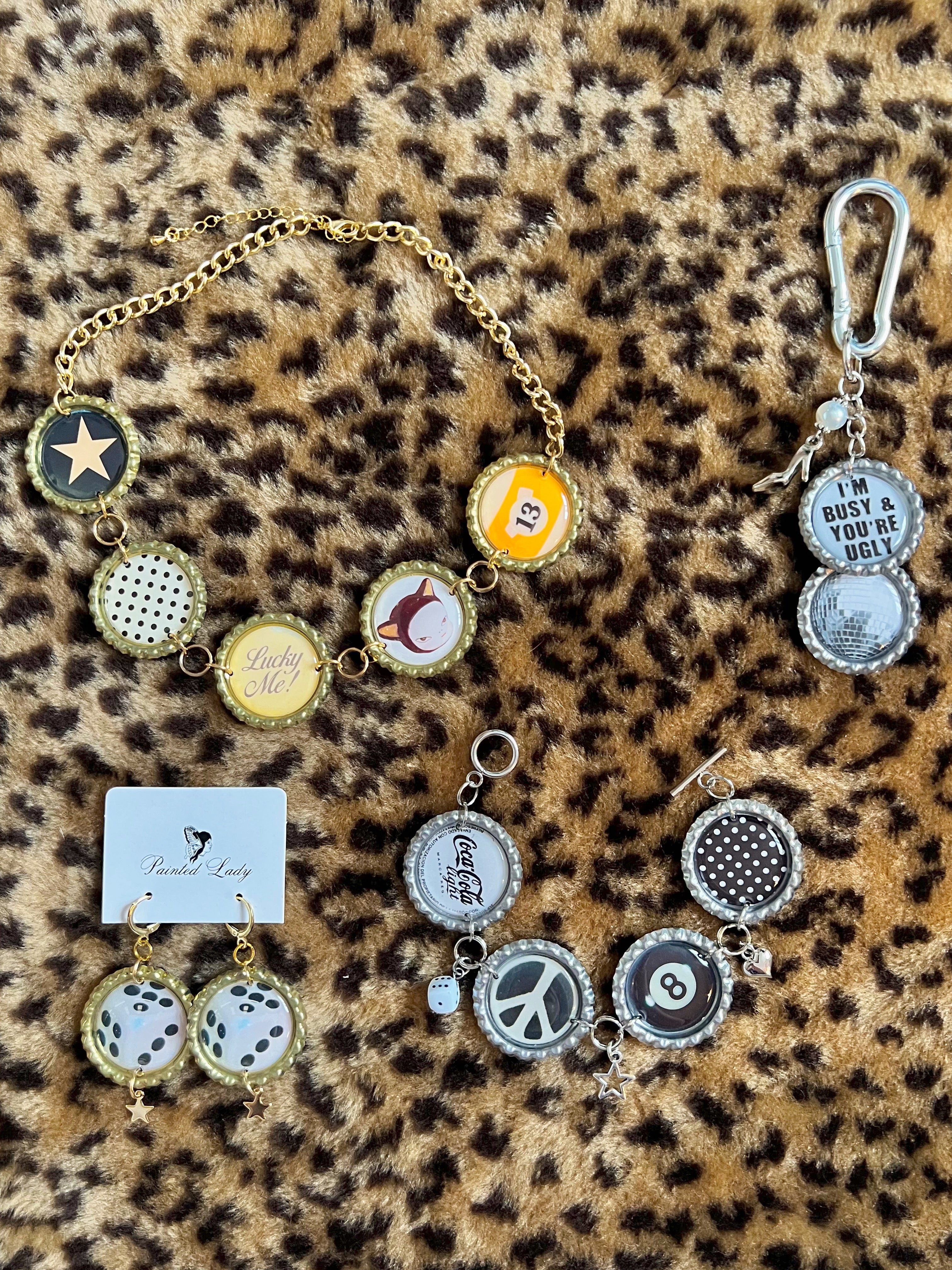 Collection of jewelry items including a bracelet and keychain on a leopard print background