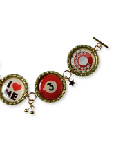 Three round charms with different designs on a white background