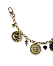 Gold chain keychain with various charms on a white background