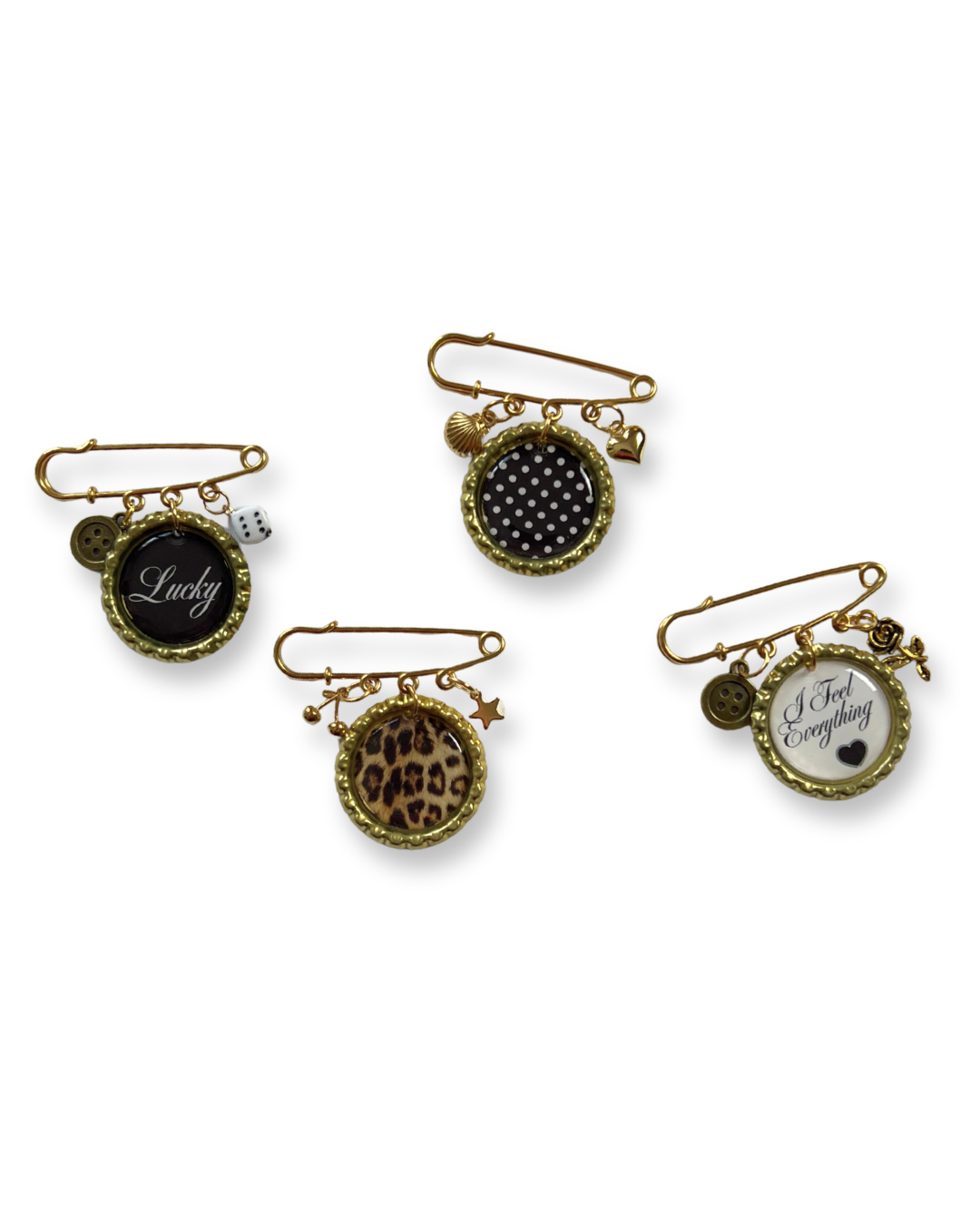 Set of four decorative pins with various designs and text on a white background