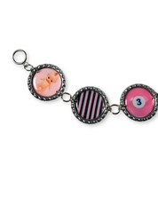 Keychain with three circular charms featuring different designs on a white background
