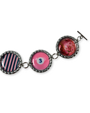 Bracelet with three circular charms featuring different designs on a white background