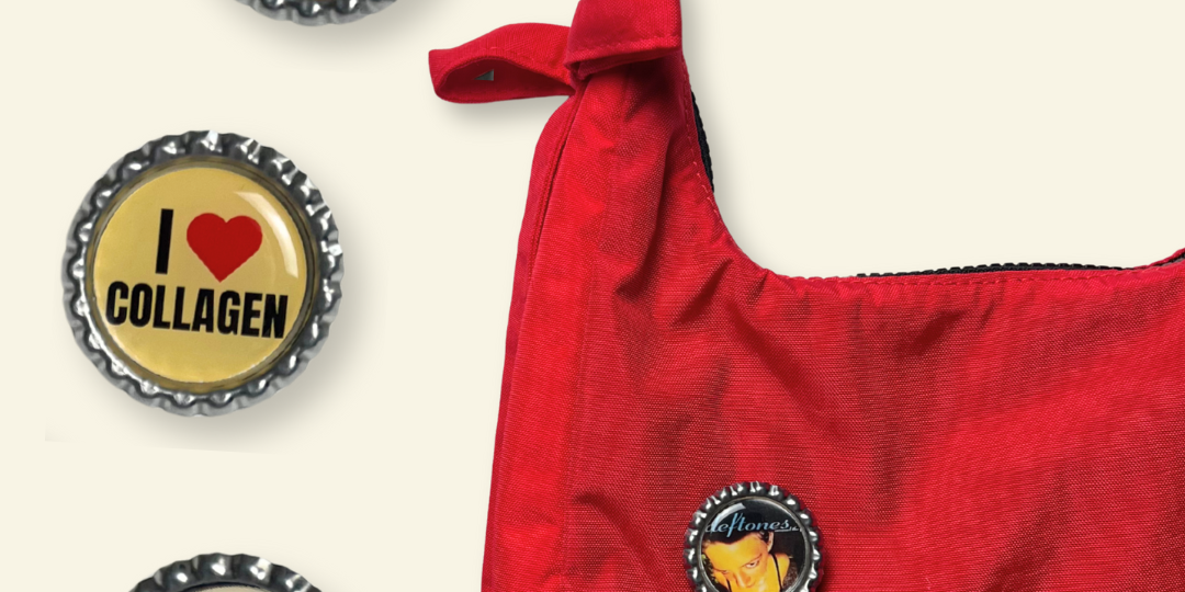 Red handbag with decorative bottle cap charms on a white background
