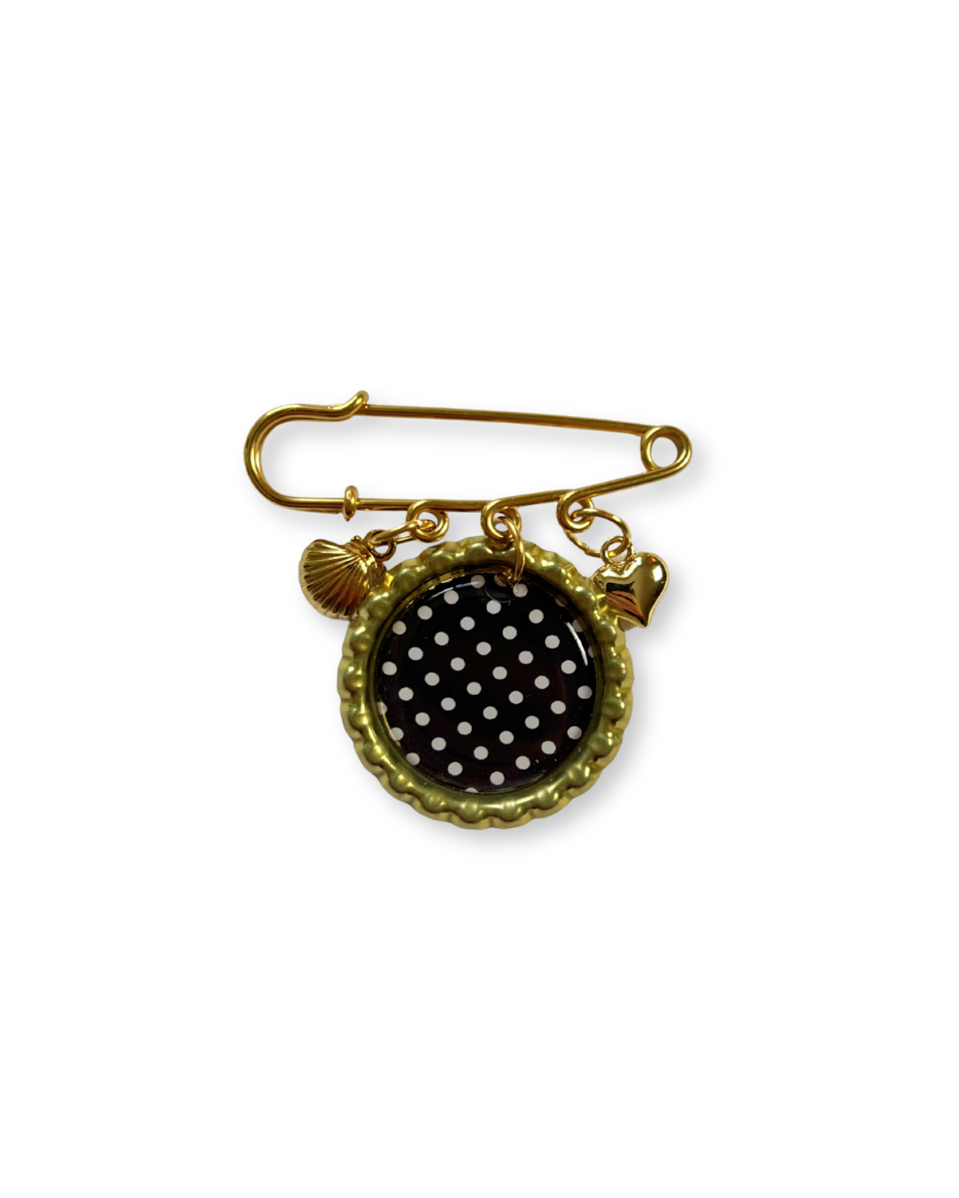 Gold brooch with black polka dot design on a white background