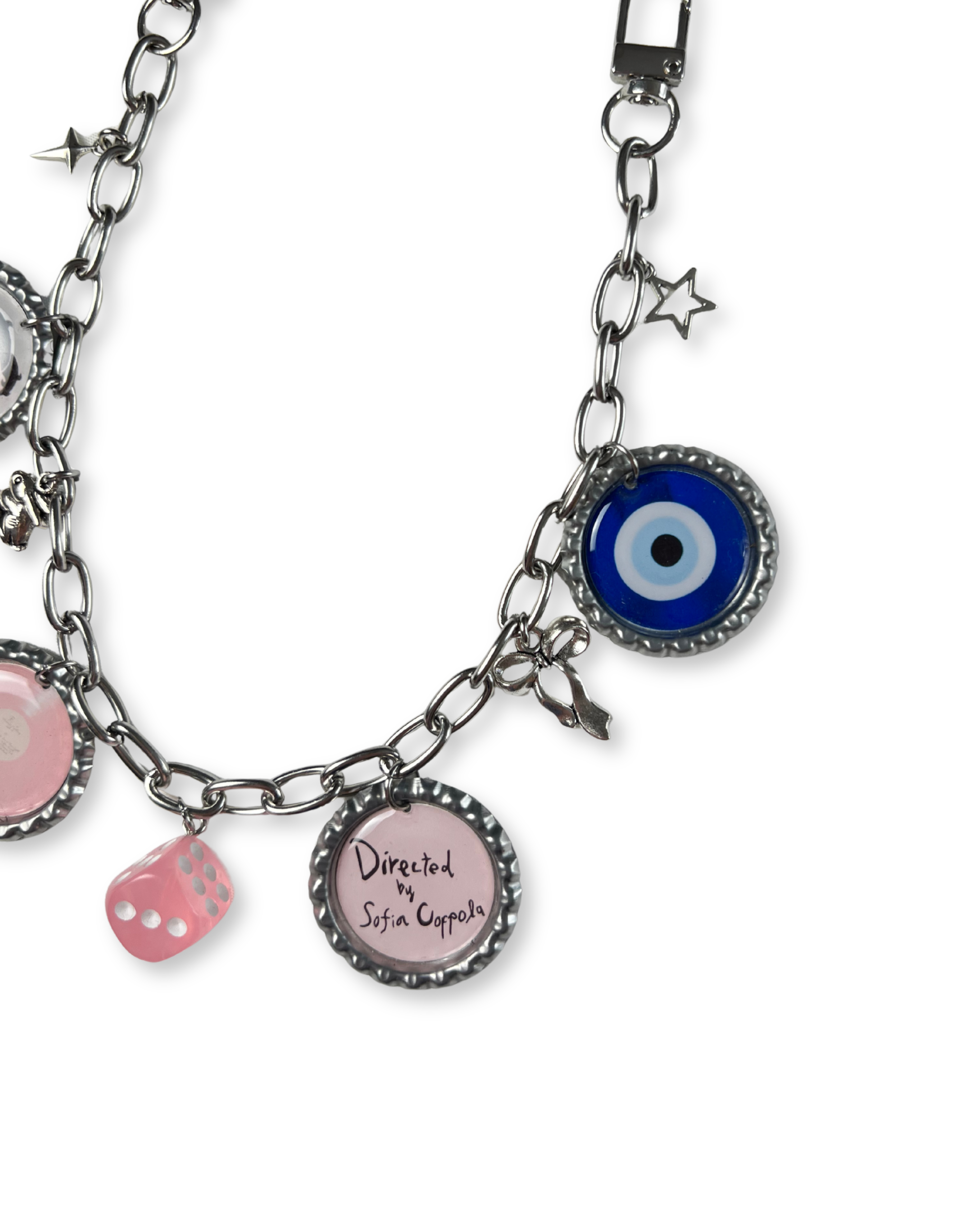 bag chain with various charms including a blue evil eye, pink dice, and round charm with text on a white background.