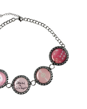 Necklace with pink and black circular pendants on a white background
