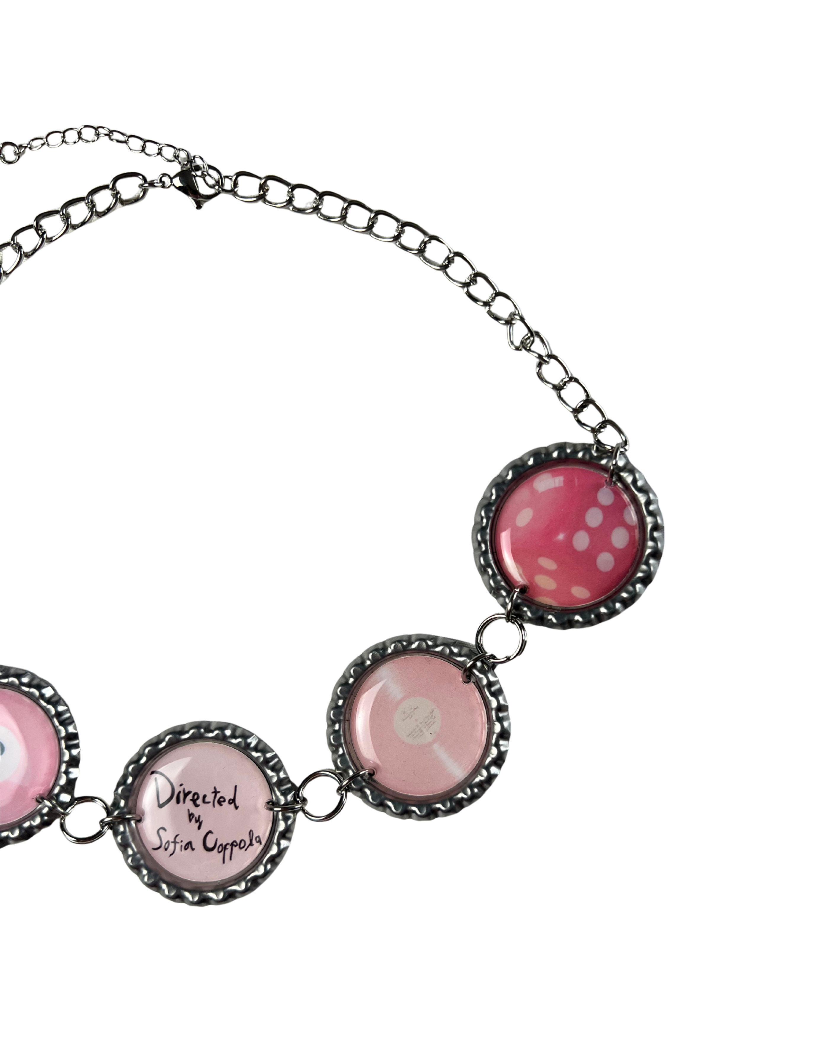 Necklace with pink and black circular pendants on a white background